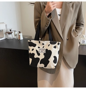 Détail du sac cabas en velours côtelé avec imprimé vache noir et blanc et étiquette