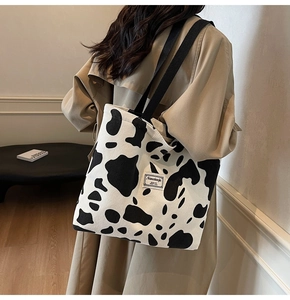 Sac fourre-tout tendance en velours côtelé imprimé vache porté par un mannequin
