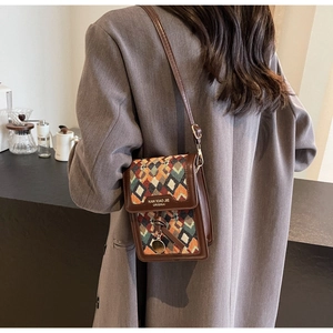 Detailed back view of a vintage crossbody bag with colorful geometric patterns and leather trim