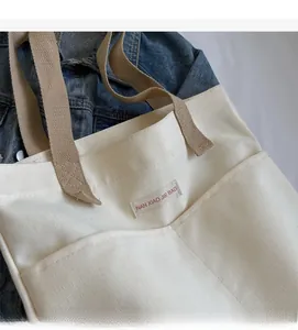 Detail of canvas tote bag with brand label on blue denim jacket background