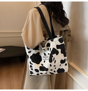 Détail du sac cabas en velours côtelé à motif vache avec texture et bandoulière noire