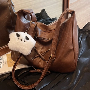 Grand sac hobo en cuir marron foncé avec laçage et porte-clés en peluche blanc