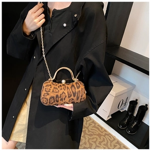 Leopard print party handbag with gold metal handle and slim chain strap worn by model