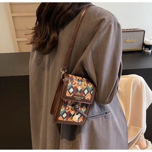 Detail of small vintage ethnic crossbody bag with geometric fabric and leather trim