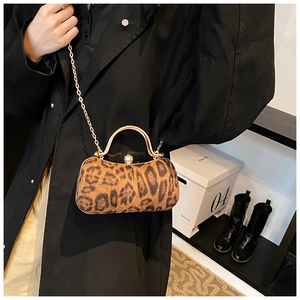 Detail of leopard print evening bag featuring gold handle and rhinestone clasp decoration