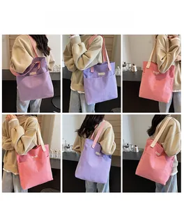 Detail of large canvas tote bag showing double front pockets and woven shoulder straps