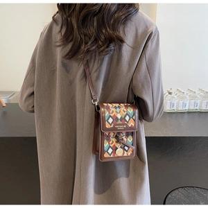 Model wearing a retro mini crossbody bag with colorful geometric patterns and brown leather