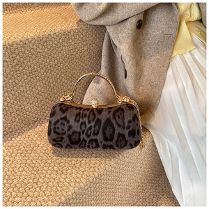 Detail of leopard print faux fur evening bag with gold metal handle and crystal clasp