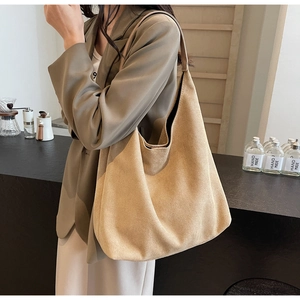 Close-up of the khaki suede texture and slouchy drape of the large hobo tote bag