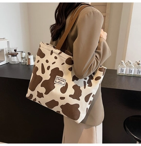 Détail d'un grand sac cabas en velours côtelé avec motif vache marron porté par un mannequin