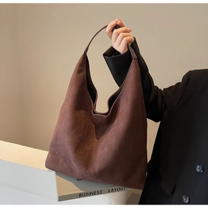 Close-up of a large coffee suede hobo bag showing its soft texture and metal detail