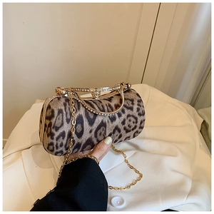 Detail of leopard print evening bag with rhinestone handle and gold metal chain strap