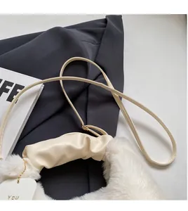 Detail of adjustable beige shoulder strap on white plush winter crossbody bag