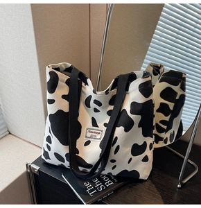 Gros plan du sac cabas en velours côtelé motif vache avec étiquette blanche tissée