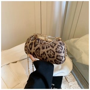 Detail of leopard print plush evening bag with rhinestone handle and gold chain strap