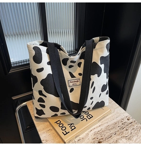 Détail du sac cabas en velours côtelé avec motif vache et poignées tissées solides
