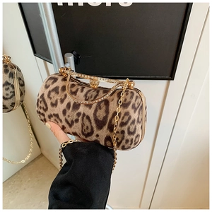 Close-up of leopard print faux fur clutch bag with rhinestone handle and gold metal chain