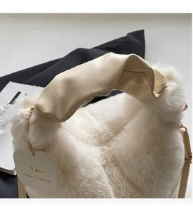 Close-up of the plush white faux fur handbag featuring a pleated beige PU leather handle