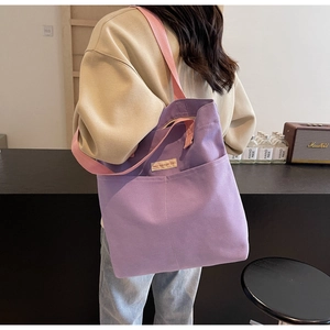 Detailed view of purple canvas tote bag with contrast straps and exterior pocket