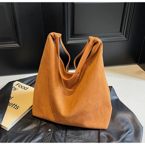 Close-up of large suede tote bag with leather handles in warm brown and tan textures