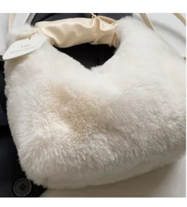 Detail of white faux fur tote bag with pleated cream satin handle and brand tag