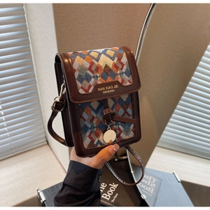 Macro view of vintage brown leather phone bag with colorful geometric jacquard fabric
