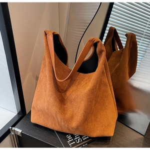 Detail of caramel suede hobo bag showing matte texture and premium leather strap