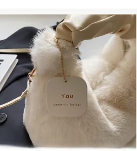 Detail of white fluffy faux fur handbag with a beige pleated handle and a quote tag
