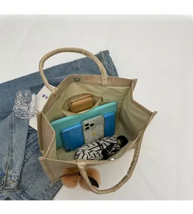 Spacious interior of beige woven tote bag showing daily items and inner zipper pocket
