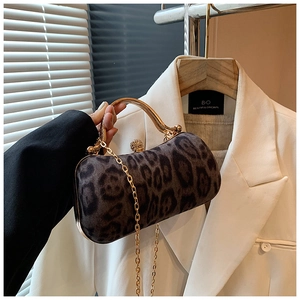 Detailed close-up of leopard print clutch bag featuring gold hardware and crystal ball clasp