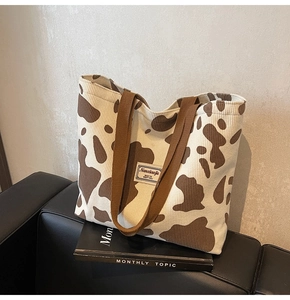 Détail du cabas en velours côtelé à motif vache avec texture rayée et bandoulière en tissu