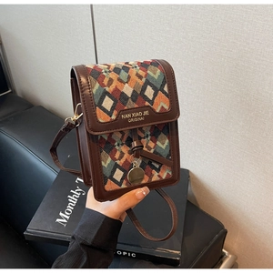 Detail of vintage crossbody bag with colorful geometric patterns and leather texture