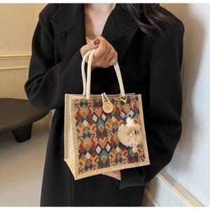 Detail of jute tote with colorful geometric patterns, rope handle and plush lamb charm