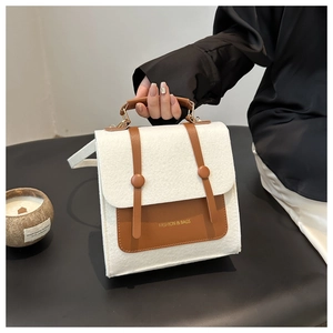 Detail of contrast stitch handbag in white felt and brown leather with shoulder strap