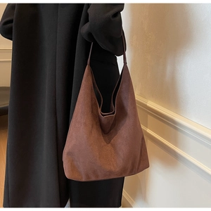 Detail of high-density brown suede tote bag with thick matte texture and durable strap