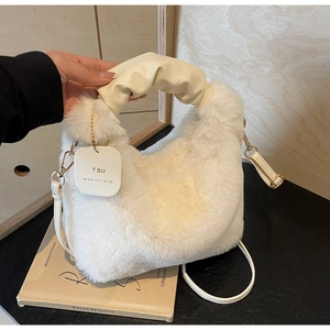 Detail of white faux fur handbag with cream pleated leather handle and gold metal hooks