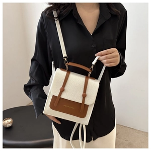 Detail of white felt and brown faux leather crossbody bag worn by a model in interior