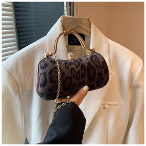 Detailed view of leopard print clutch featuring gold arched handle and chain strap