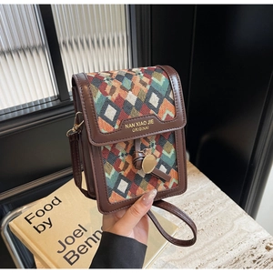 Detail of vintage mini crossbody bag with colorful geometric woven pattern and leather trim