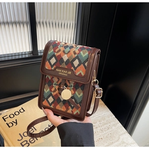 Detail of colorful geometric jacquard pattern on a retro crossbody bag with gold accents