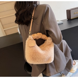 Detail of plush faux fur shoulder bag with ruched handle shown in a cozy winter setting
