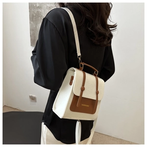 Detailed back view of a white felt and brown leather backpack on a model