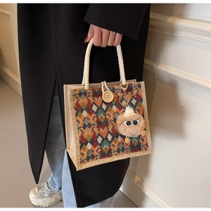 Detail of colorful geometric jute bag with woven rope handles and wooden button