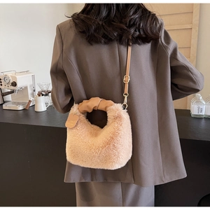 Detail of soft plush crossbody bag with leather rolled handle and adjustable metal strap