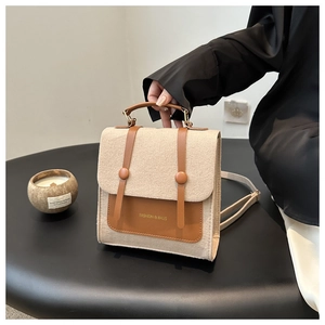 Detail of vintage beige felt crossbody bag with brown leather straps and FASHION logo