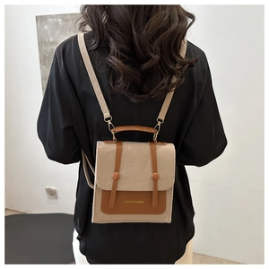 Detail of minimalist beige felt crossbody bag with brown leather flap and top handle