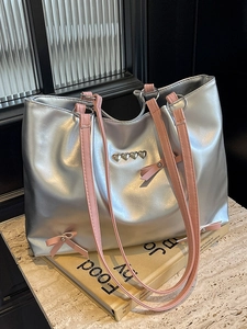 Silver metallic tote bag with pink bow ribbon and heart charms for casual commute