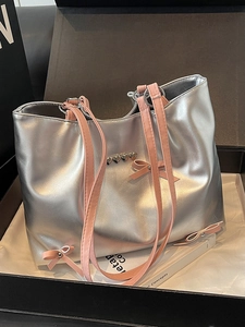 Large silver tote bag with pink bow and metallic heart detail for casual commute