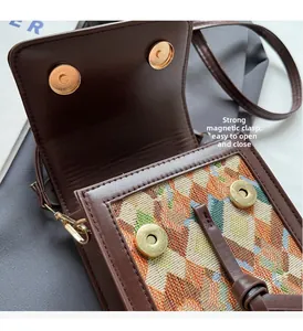Detail of the strong magnetic closure on a brown crossbody bag with woven patterns