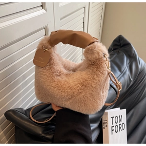 Detail of plush faux fur handbag with brown pleated leather handle and detachable strap